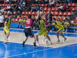 Jugador del Bm. Burgos pasando el pase al su pivote entre defensores del Trops Málaga