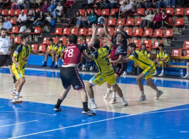 Jugador del Bm. Burgos pasando el pase al su pivote entre defensores del Trops Málaga