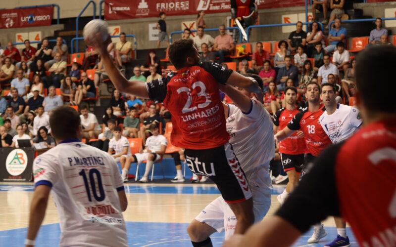 Jugador del Balonmano Burgos defendido mientras ejecuta un lanzamiento.